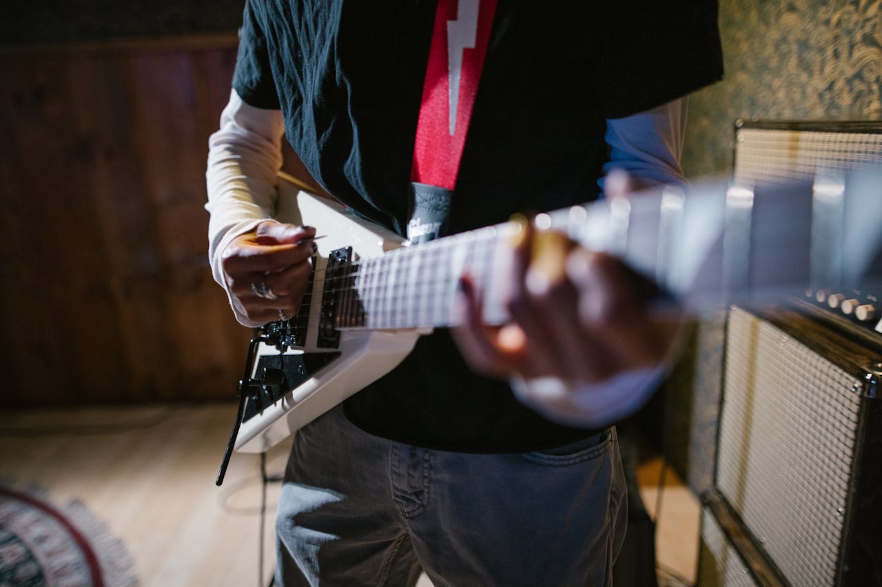 why-choose-us Close-up of a musician playing an electric guitar indoors, focus on hands and instrument.